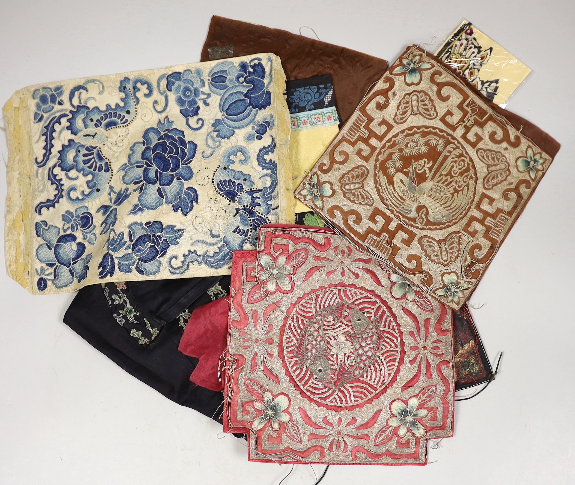 A collection of mixed Chinese polychrome and metallic thread embroidered panels, including a Chinese knot embroidered apron and blue embroidered panel, 19th/20th century